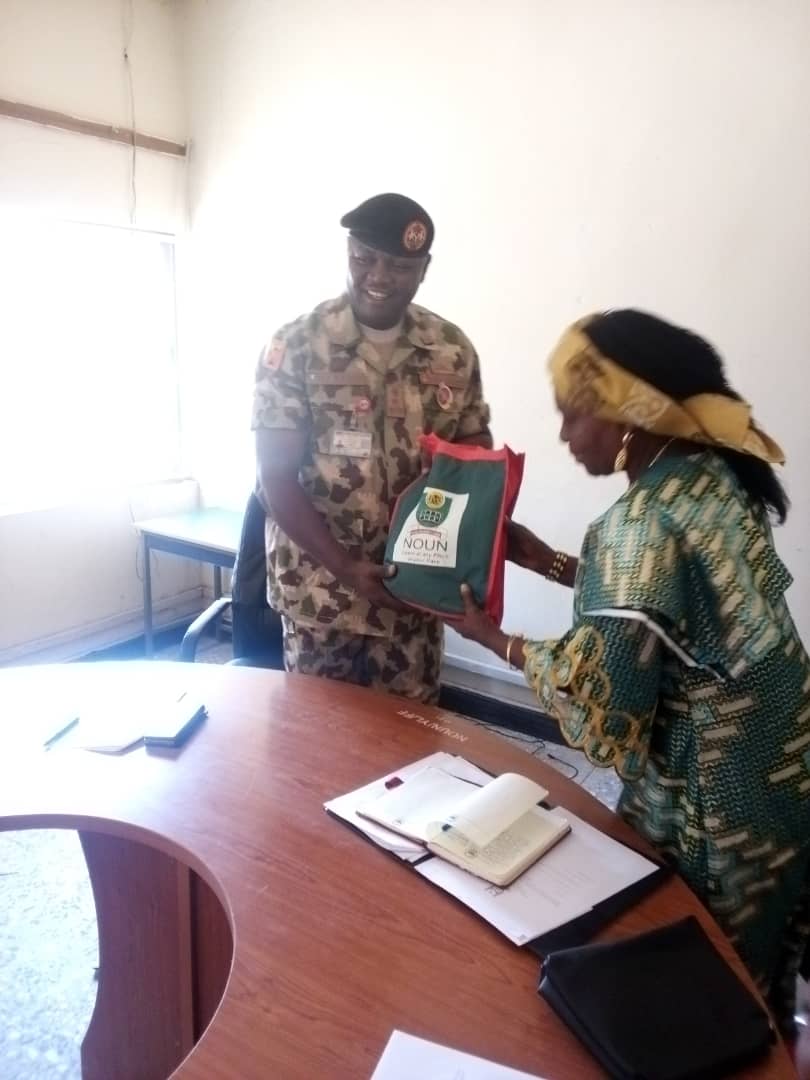 Mrs Yelyel presenting NOUN souvenir to Major General Gambo