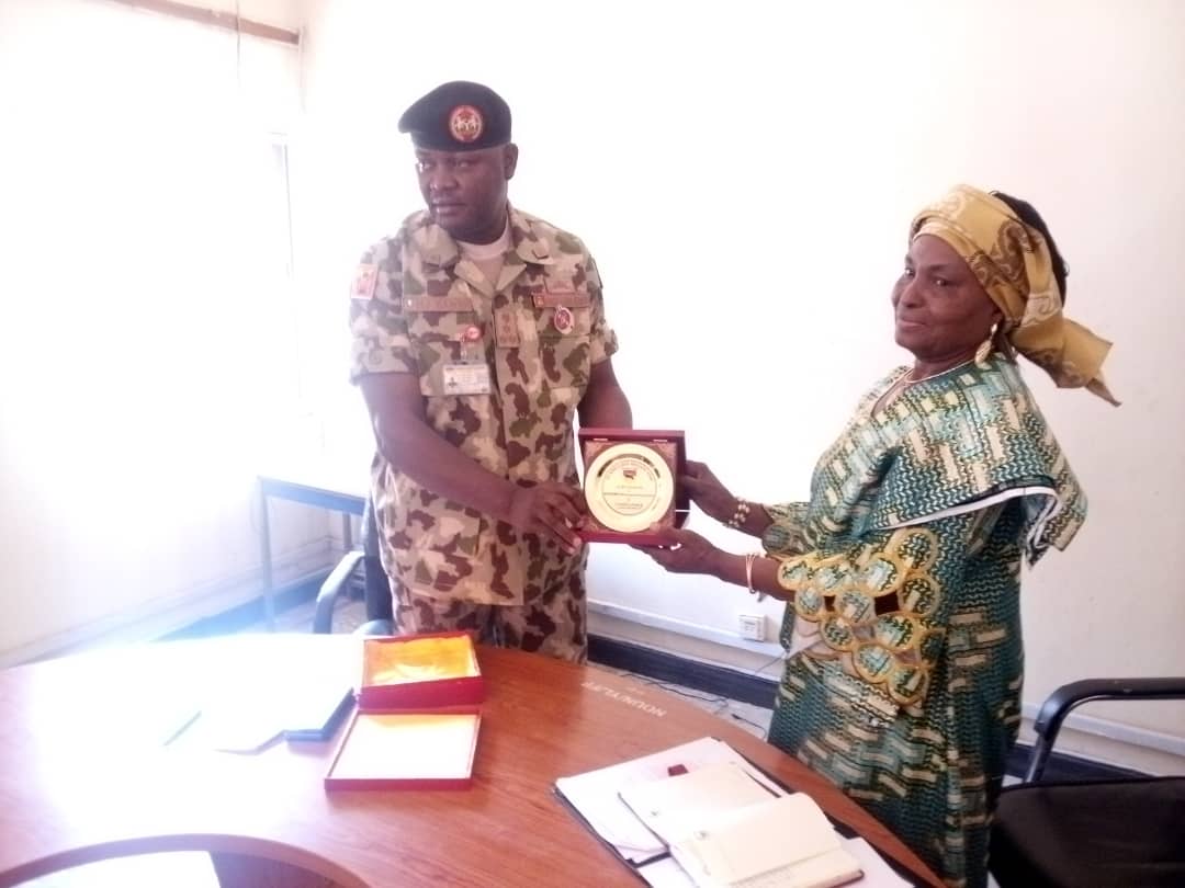 Major General Gambo presenting award of excellence to the center director